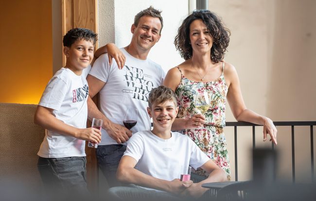 La famiglia ospitante Stuppner, Anke e Andreas con i loro due figli, davanti a un muro di pietra nel giardino