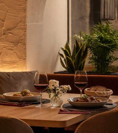 Un tavolo con piatti tradizionali altoatesini: Knödel, Gulasch, Schlutzkrapfen, pane e formaggio