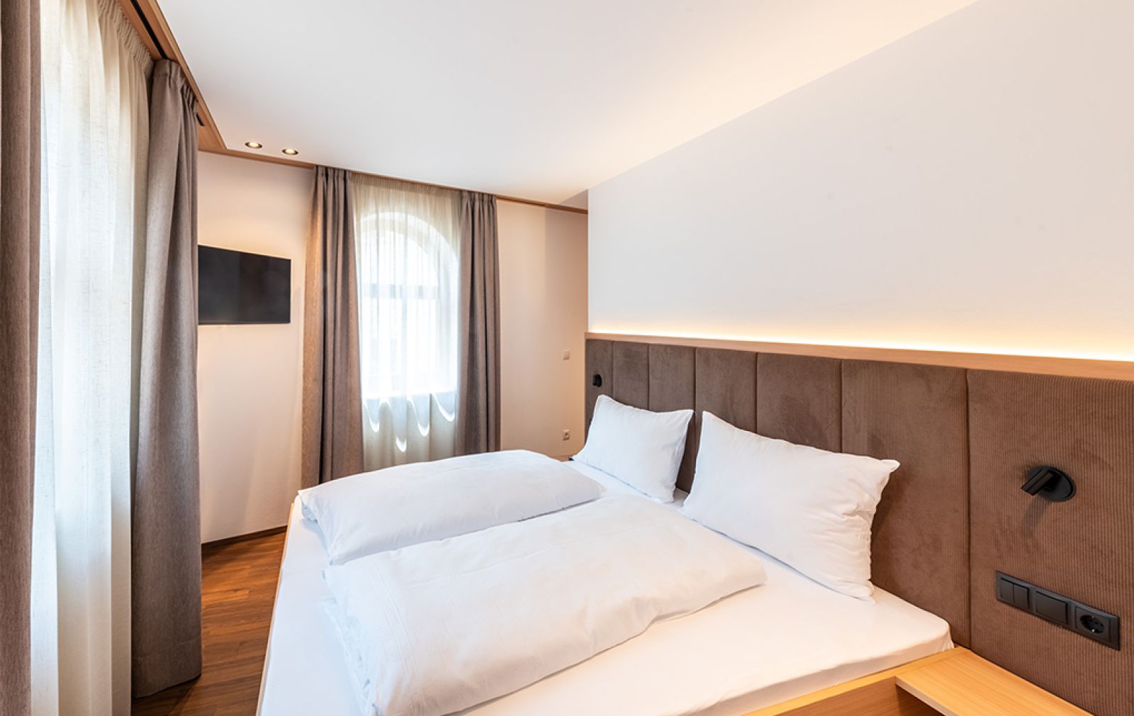 Modernes Appartement  in Truden: Heller Wohnbereich mit Sofa, Couchtisch, TV und offener Küche mit Esstisch